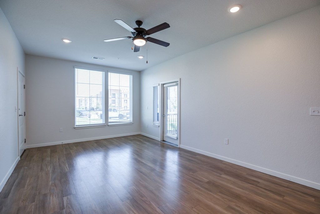 Living room with a ceiling fan and wooden flooring.
