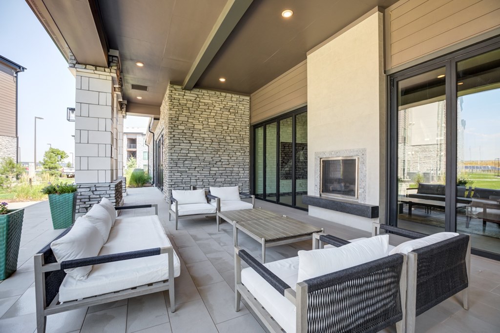 Outdoor lounging area with a couch, chairs, and a table.