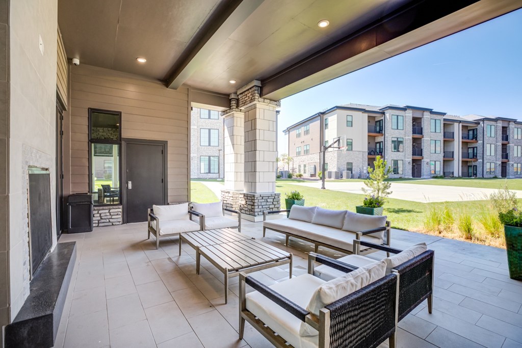 A patio with a table and chairs is shown with a basketball court in the background.
