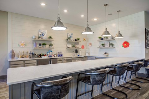 a long white bar with chairs in a kitchen