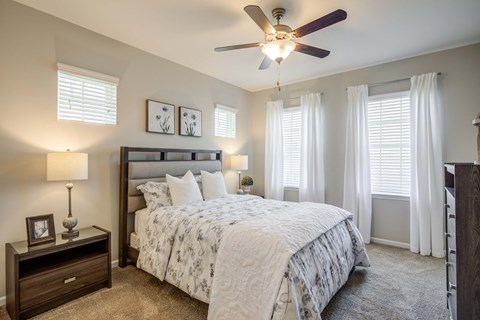 a bedroom with a bed and a ceiling fan