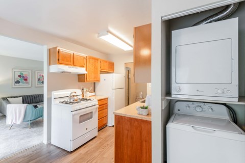 a kitchen with a washer and dryer and a white stove and refrigerator
