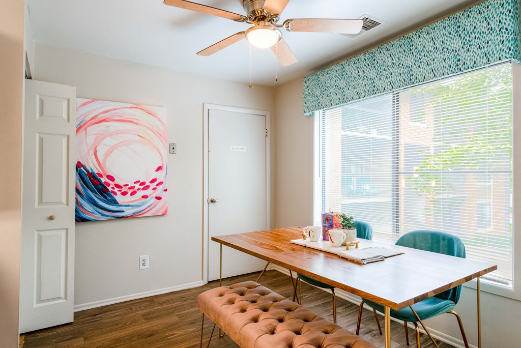 a dining room with a table and chairs and a ceiling fan