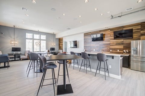 a kitchen and dining area with bar stools and a table with chairs