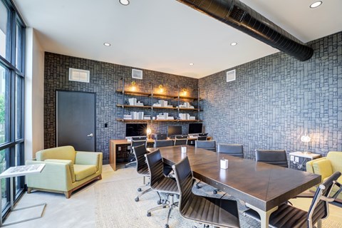 A conference room with a long table surrounded by chairs.