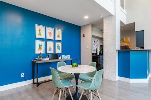 a dining room with blue walls and a table and chairs