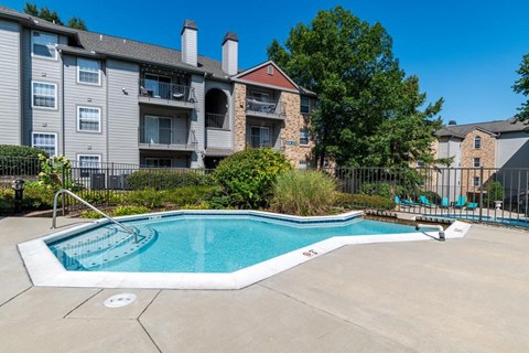 a swimming pool with an apartment building in the background