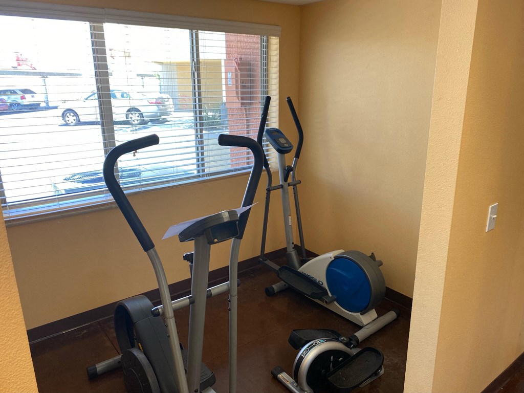 a gym with two exercise machines and a large window