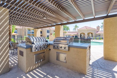 A modern outdoor kitchen with a grill and sink.