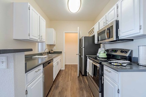 A kitchen with white cabinets and stainless steel appliances