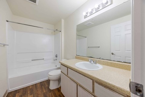 A white bathroom with a sink, toilet, and mirror.