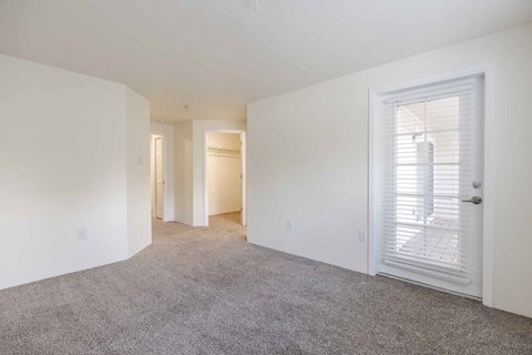 A bedroom with a carpeted floor and a door leading to a patio.