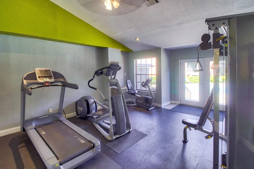 a gym with exercise equipment and a glass door