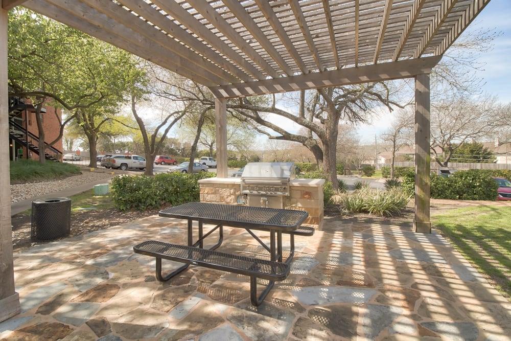 a patio with a grill and a picnic table