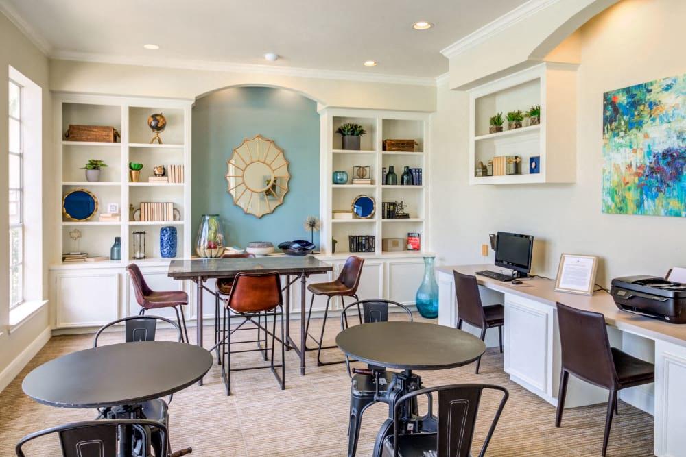 a living room with tables and chairs and a computer