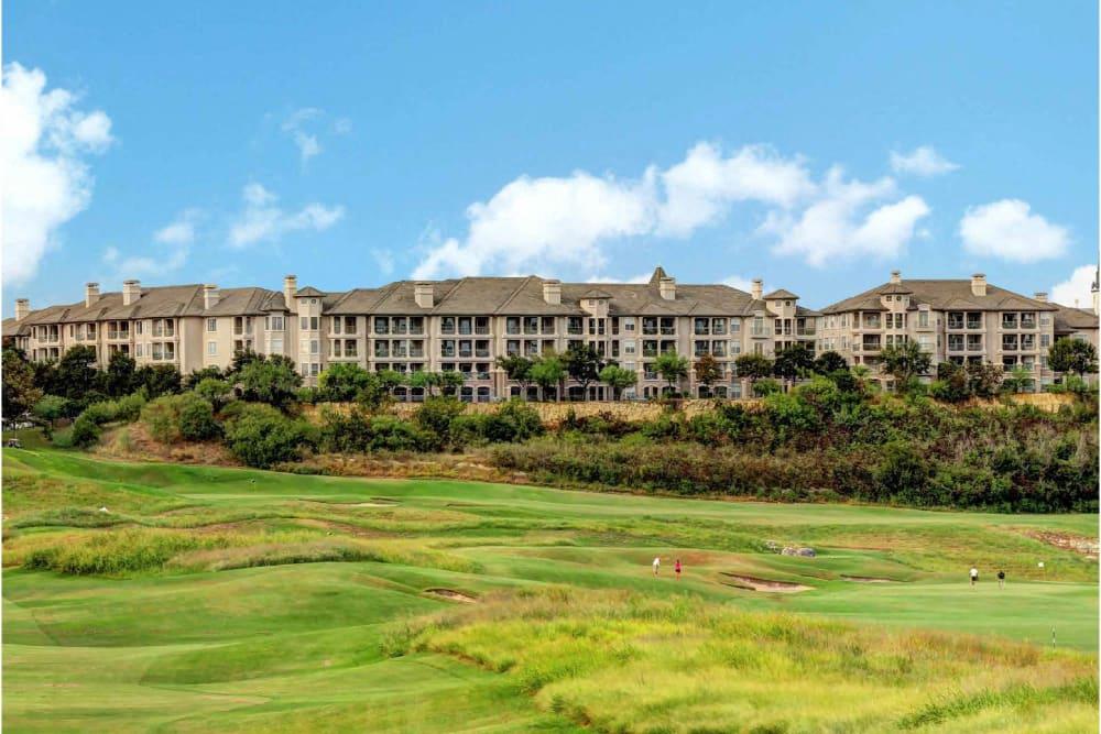 a view of a golf course with condos in the background