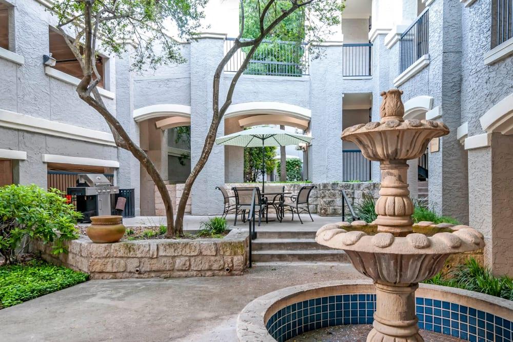 a courtyard with a fountain and a table and chairs