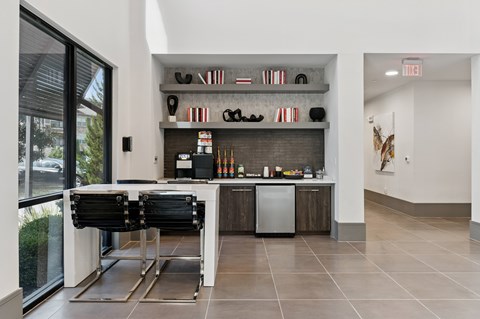 A kitchen with a black counter top and a white wall.
