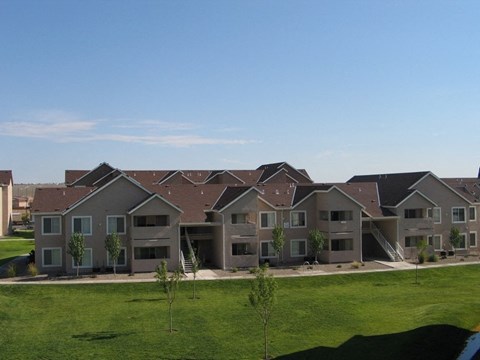 A row of houses with green lawns in front.