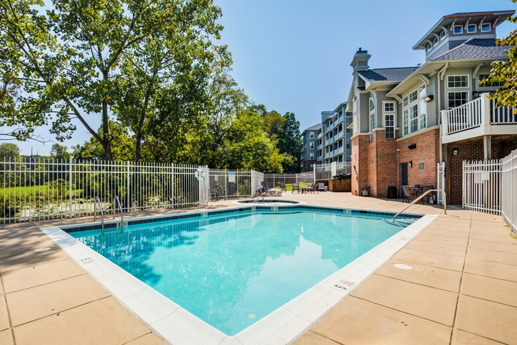 swimming pool with apartment building and trees