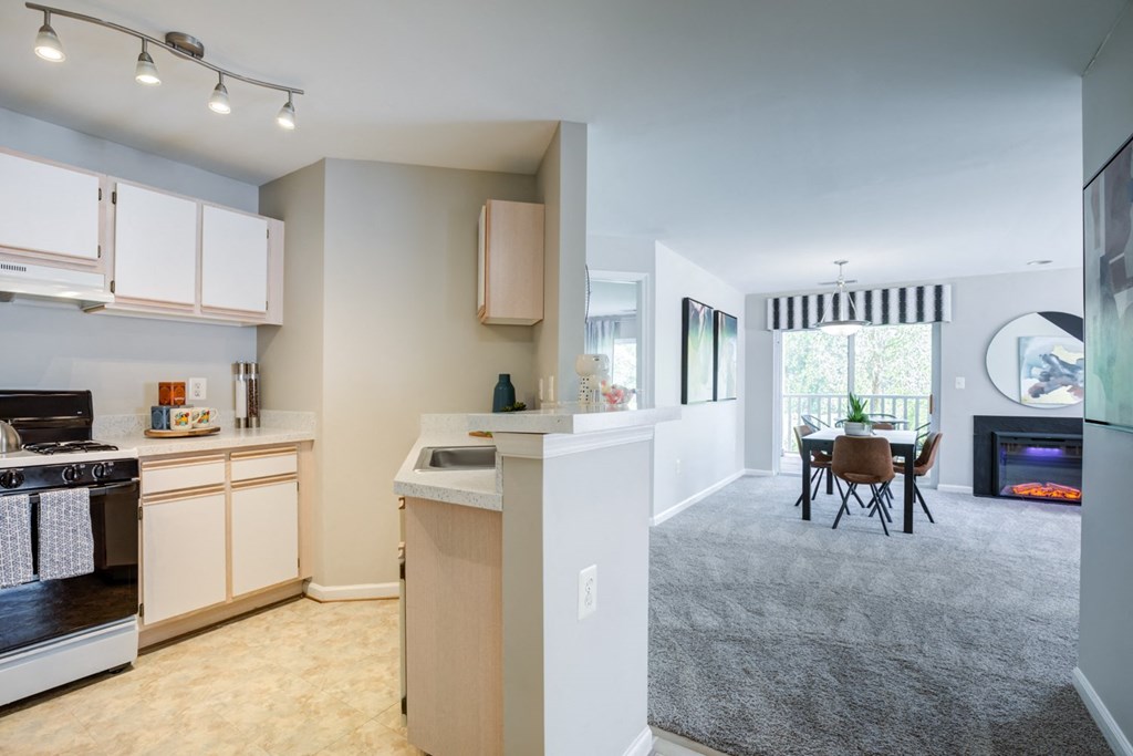 a kitchen and living room with a dining area and a table