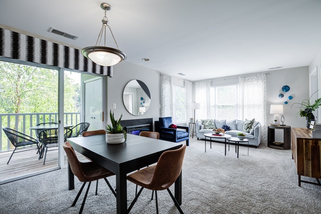 a living room and dining room with a table and chairs