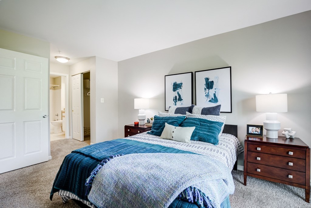 a bedroom with a bed and two night stands and a closet