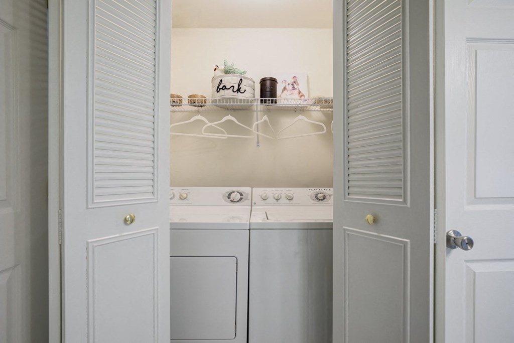 a white laundry room with white appliances and white cabinets