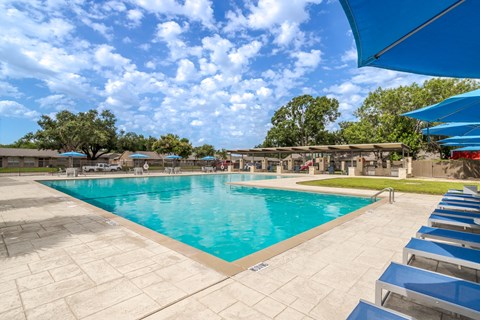 a swimming pool with chairs and umbrellas at the resort