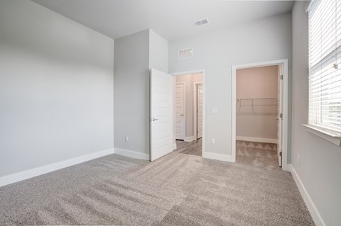 Carpeted bedroom with closet