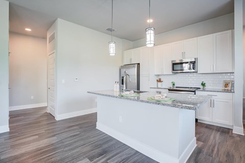 Kitchen with hardwood style floors and kitchen island with granite countertop