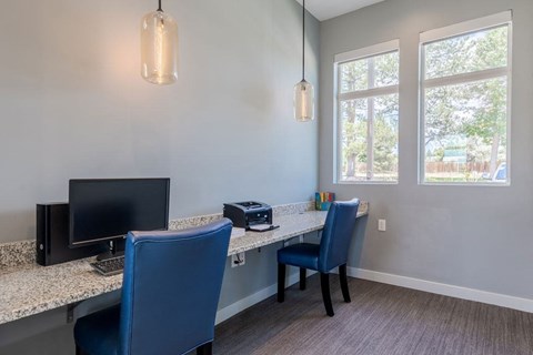 an office with two chairs and a desk with a computer