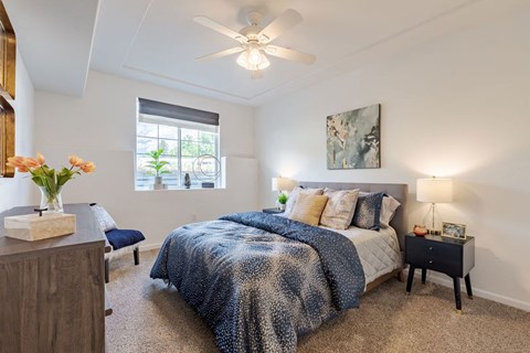 a bedroom with a bed and a ceiling fan