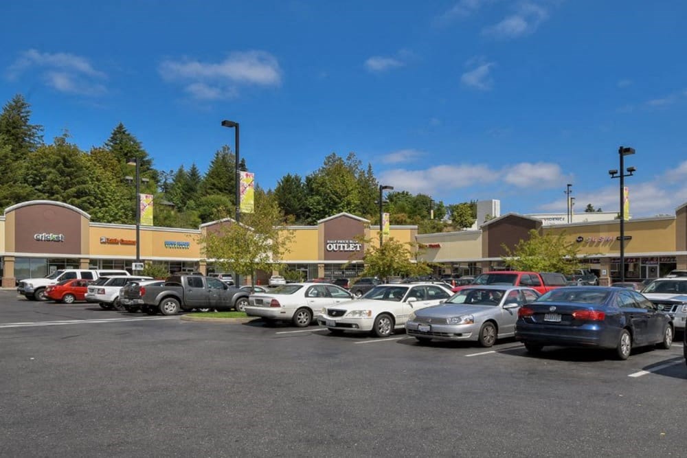 a parking lot full of cars in front of a shopping center