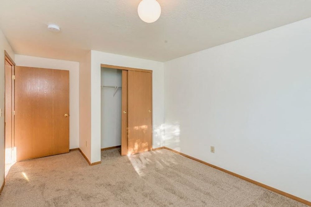an empty living room with a door to a closet