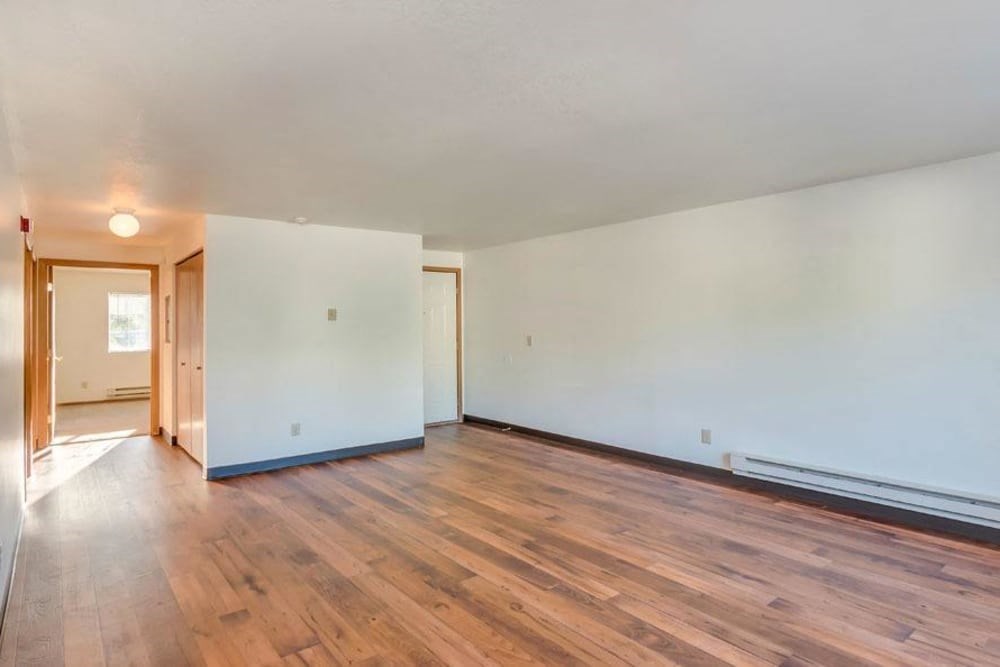 an empty living room with white walls and wood floors