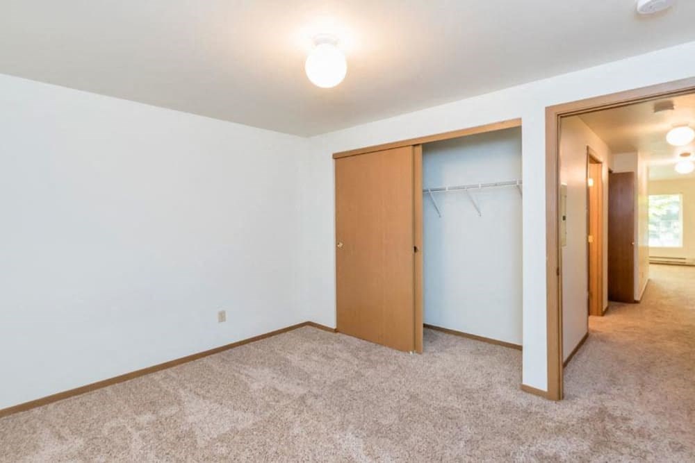 an empty living room with a closet and a door to a bathroom