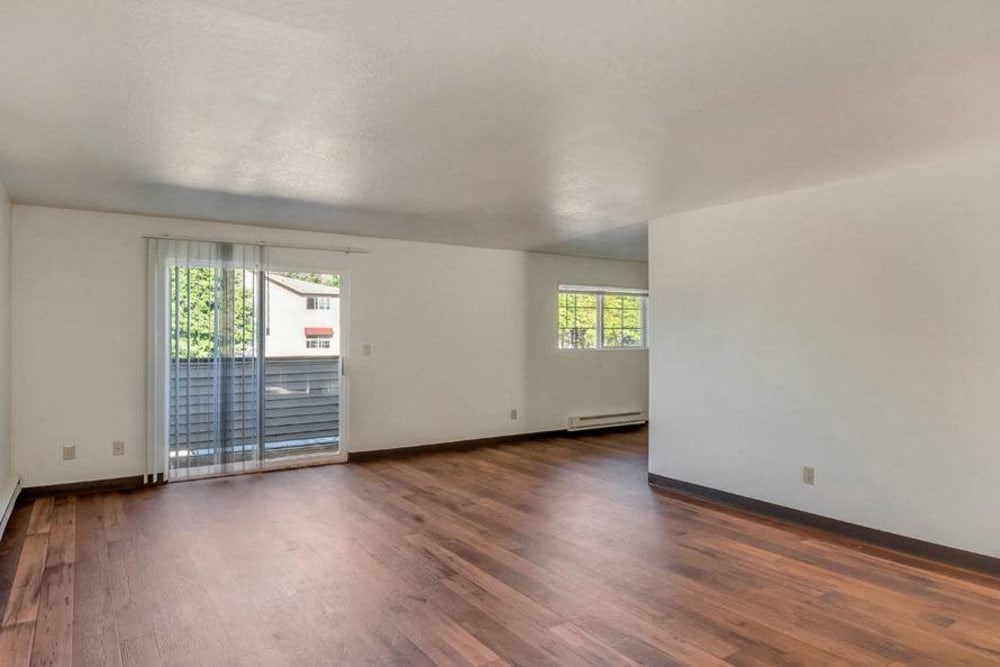 an empty living room with wood floors and a sliding glass door