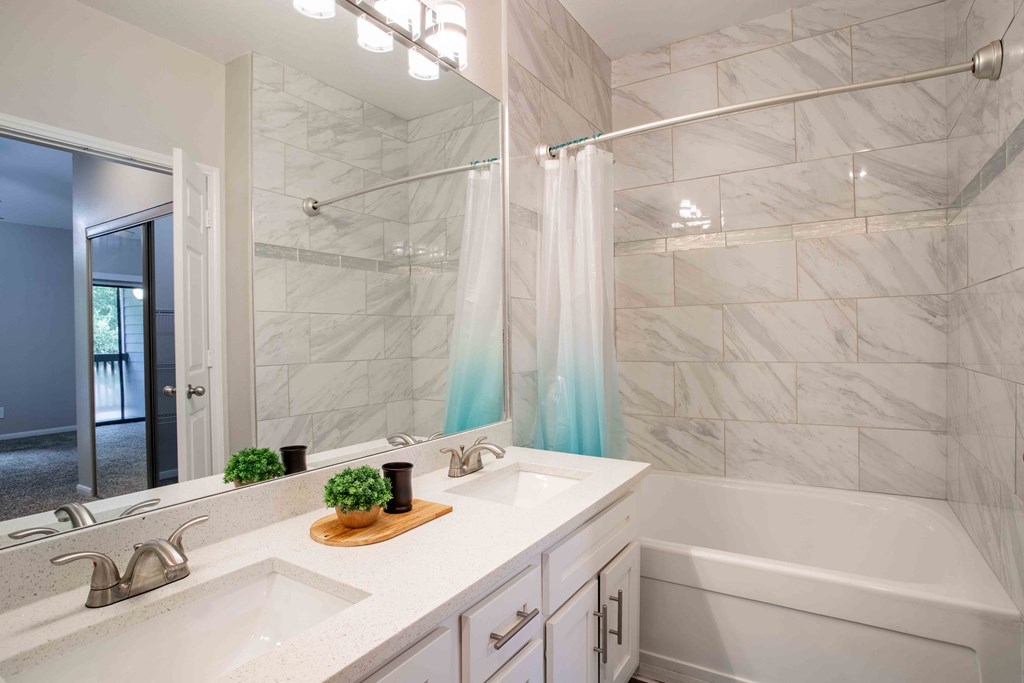 a bathroom with two sinks and a shower and a tub