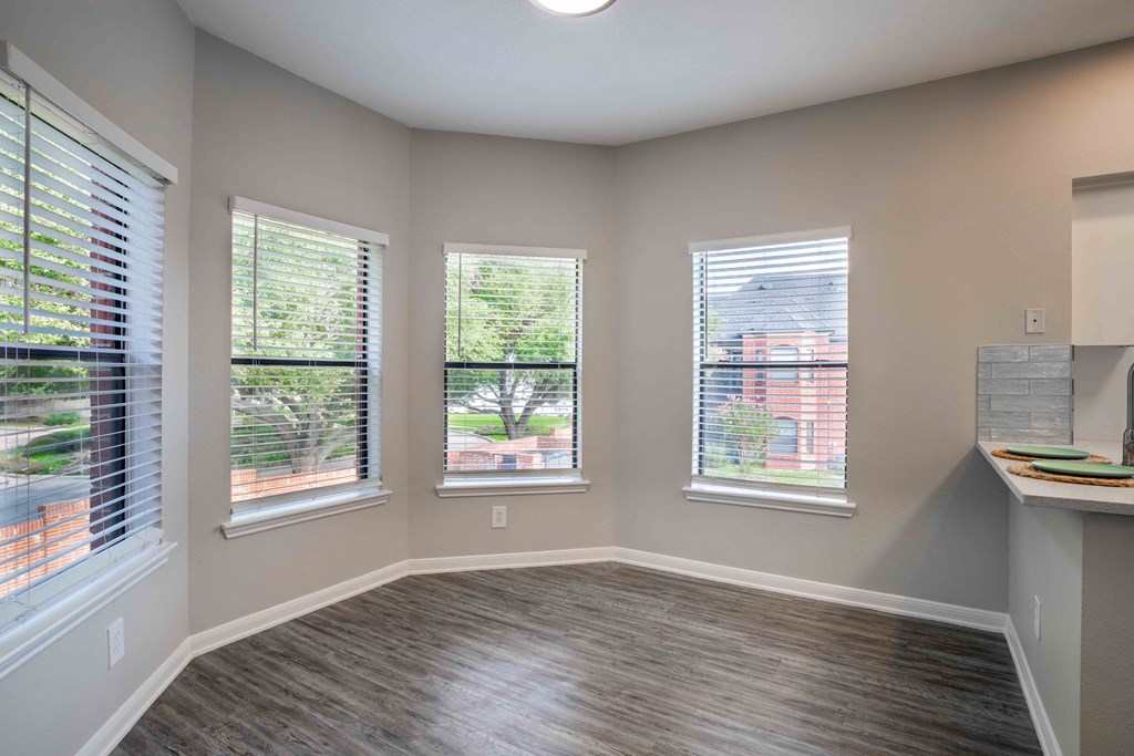 a living room with a hard wood floor and three windows
