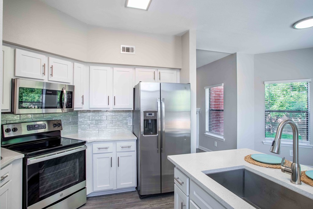 a kitchen with stainless steel appliances and white cabinets