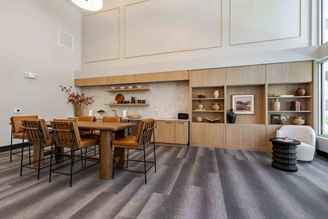 A dining area with a wooden table and chairs in the clubhouse