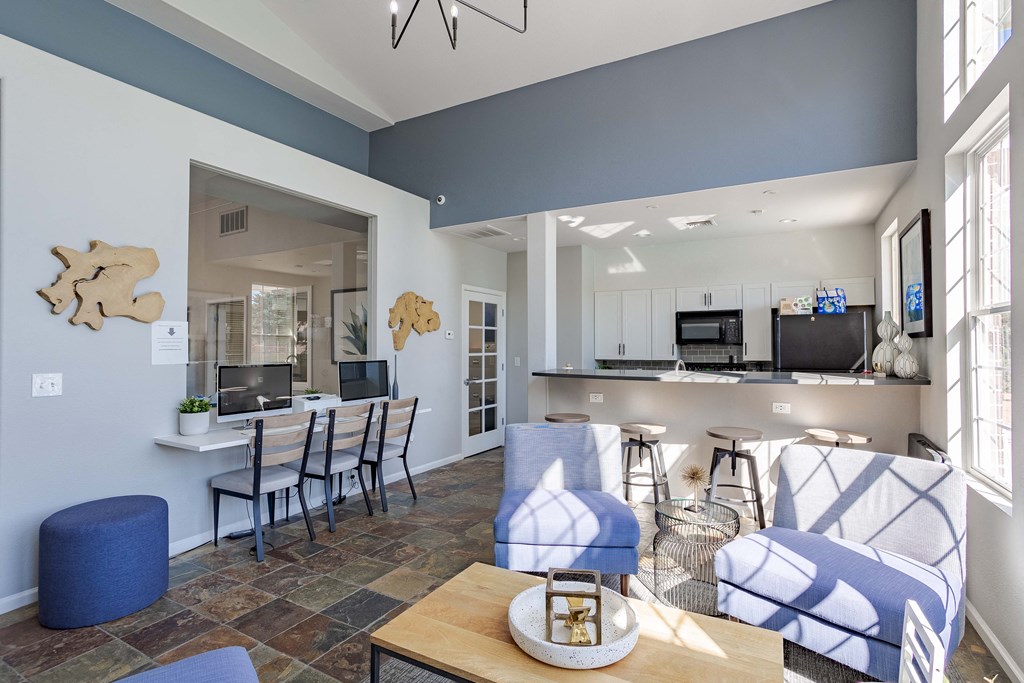 lounge area with blue and white furniture and a kitchen