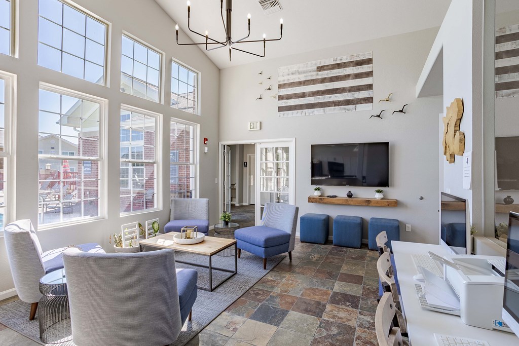 lounge area with blue chairs and a tv
