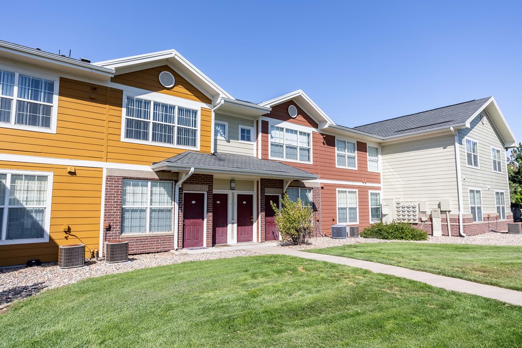 a row of homes with a lawn and a sidewalk