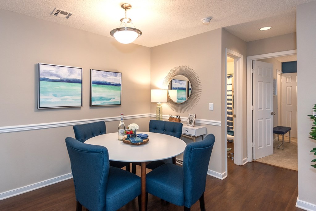 A dining room with a white table and blue chairs.
