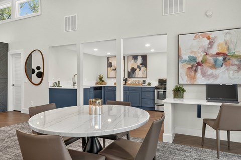 A modern dining room with a round table and chairs.