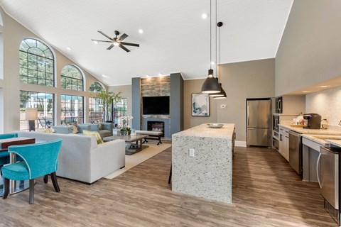 A modern kitchen and living room with a blue chair and a fireplace.