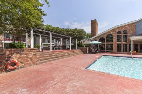 A pool area with a brick wall and a lifebuoy.