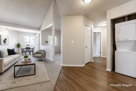 A virtually staged living room with a couch, coffee table, and a dining table.